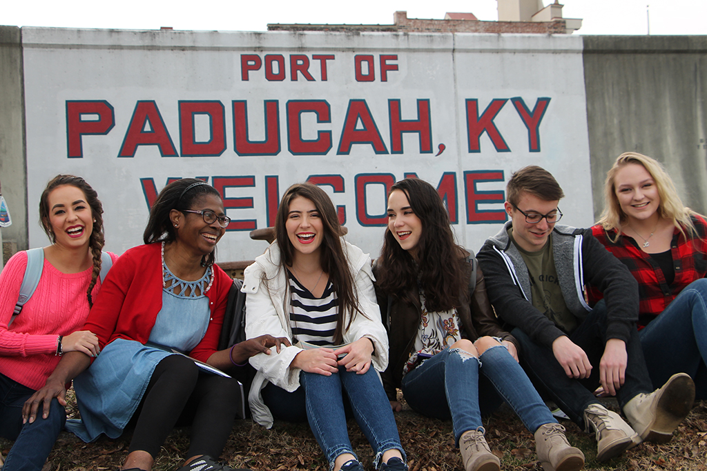 people on wall in front of paducah, KY port sign