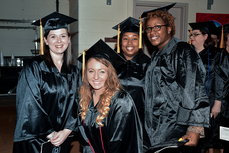 a group of students smiling at graduation