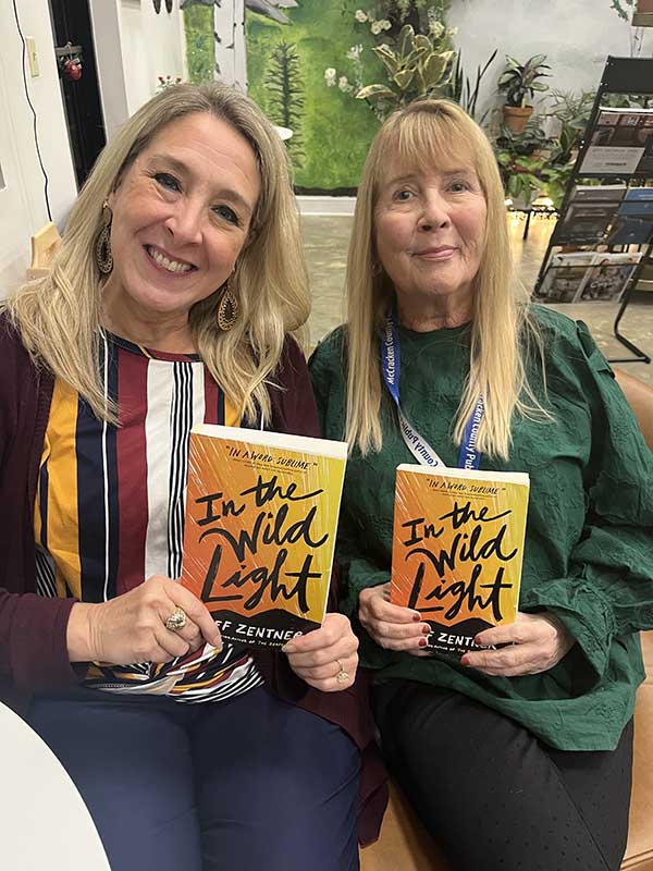 2 ladies holding the In the Wild Light book.
